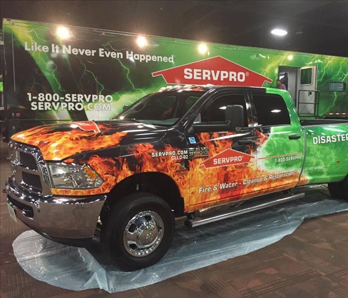  SERVPRO pick-up truck with and fire and lightening wrap parked in front of SERVPRO trailer with lightening wrap