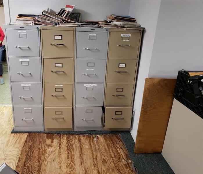 Carpet removed around a row of filing cabinets.