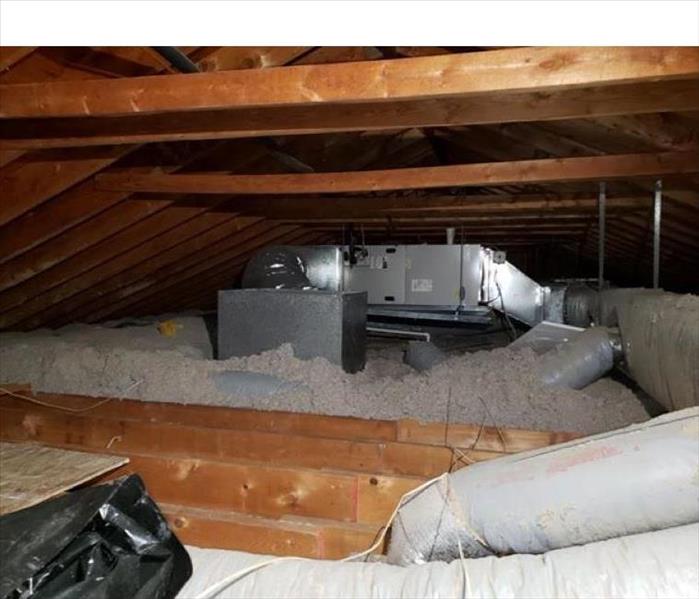 Attic space with insulation and a HVAC system.