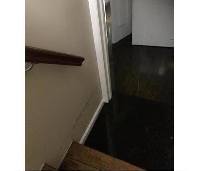 Bottom of the stairs that has a water line above the first step.